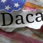 DACA typed on paper on top of an american flag